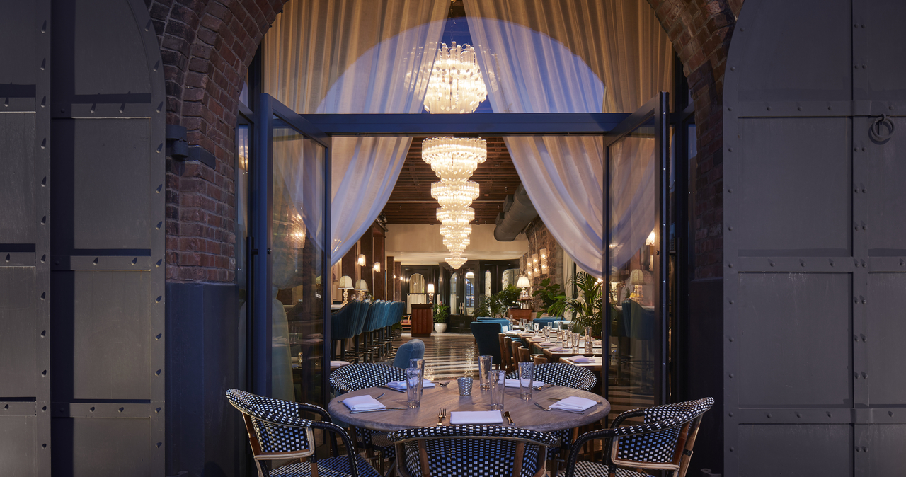 A view of the restaurant through French doors at night